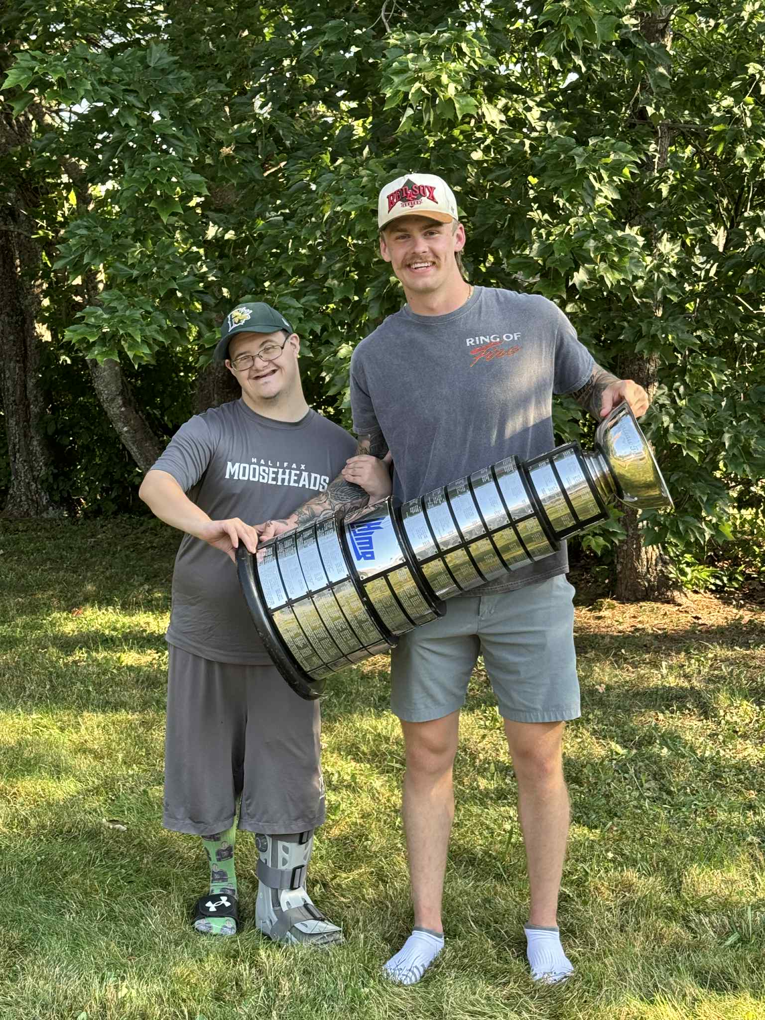 Tyler and a hockey friend holding a championship cup